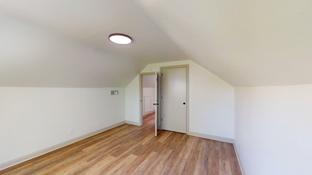 bonus room featuring baseboards, vaulted ceiling, and light wood-style flooring