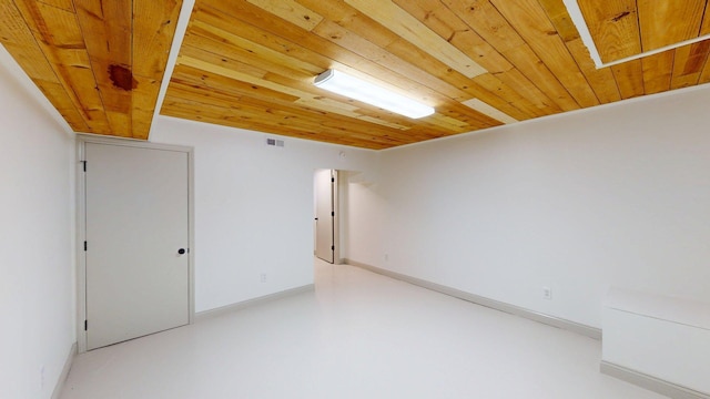 unfurnished room featuring wooden ceiling, baseboards, concrete floors, and visible vents