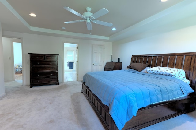 bedroom with recessed lighting, connected bathroom, light colored carpet, ceiling fan, and a raised ceiling
