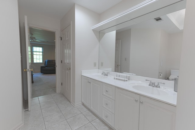 bathroom with a sink, double vanity, visible vents, tile patterned floors, and a ceiling fan