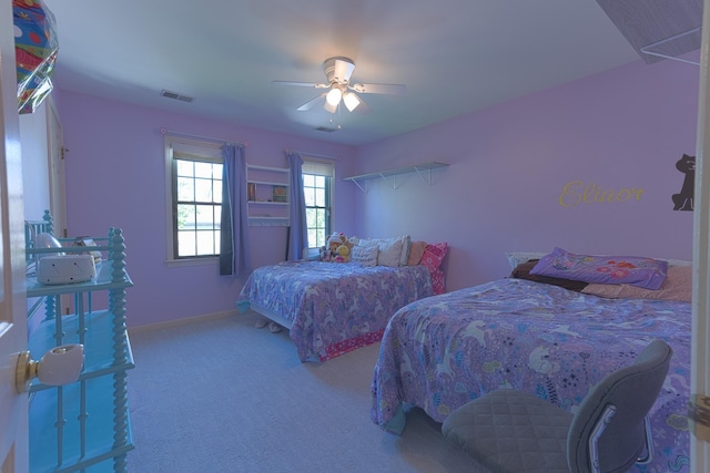 carpeted bedroom with visible vents, ceiling fan, and baseboards
