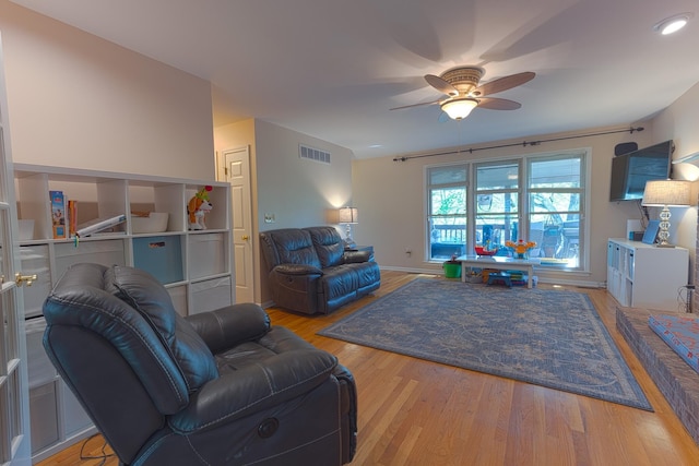 living area featuring visible vents, ceiling fan, and light wood finished floors