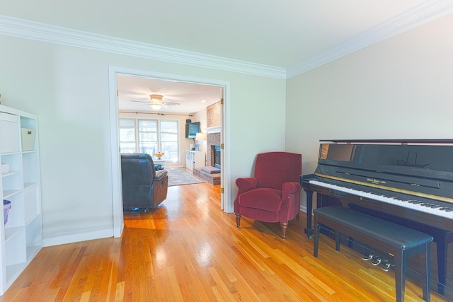 living area with baseboards, light wood-type flooring, and ornamental molding