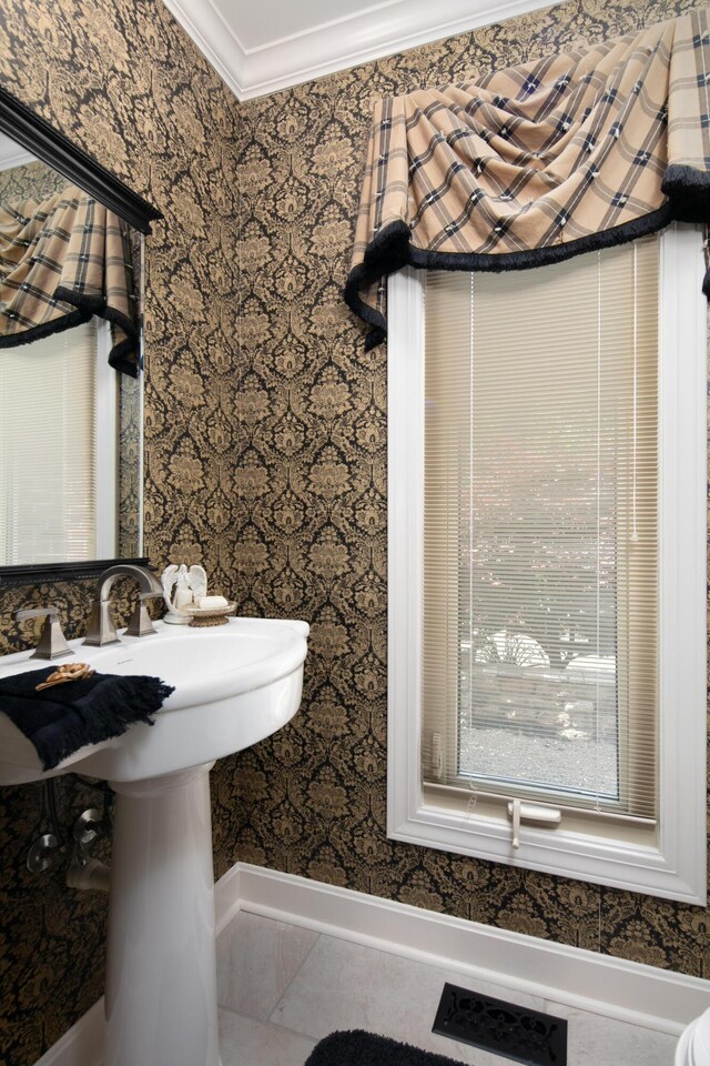 bathroom with crown molding and wallpapered walls