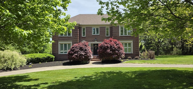 colonial-style house with brick siding and a front lawn