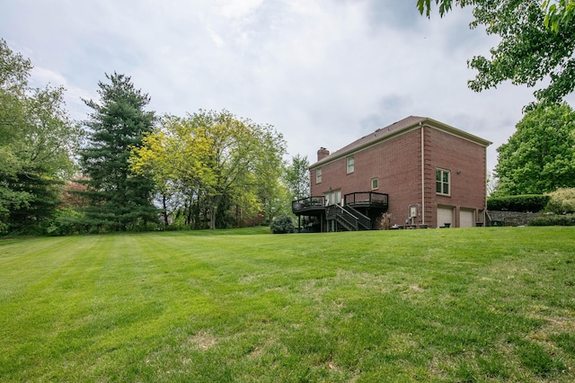 view of yard with stairs, a garage, and a deck