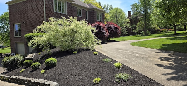 view of side of property featuring a lawn and brick siding