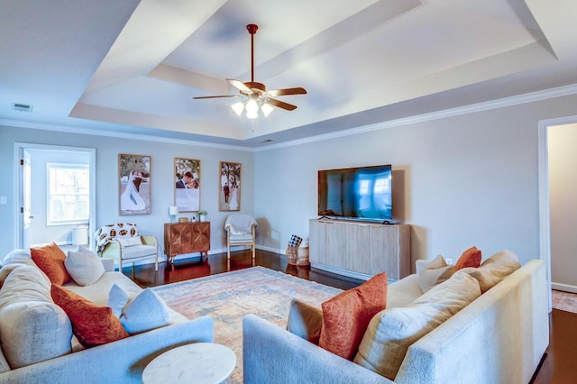 living area featuring visible vents, wood finished floors, a ceiling fan, and a tray ceiling