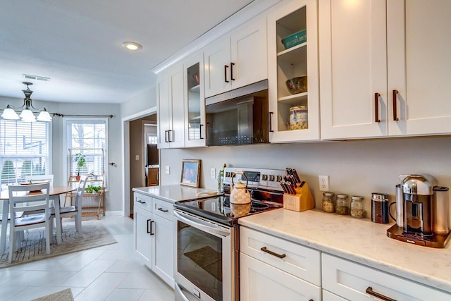 kitchen with light tile patterned flooring, visible vents, light stone counters, white cabinetry, and stainless steel electric stove