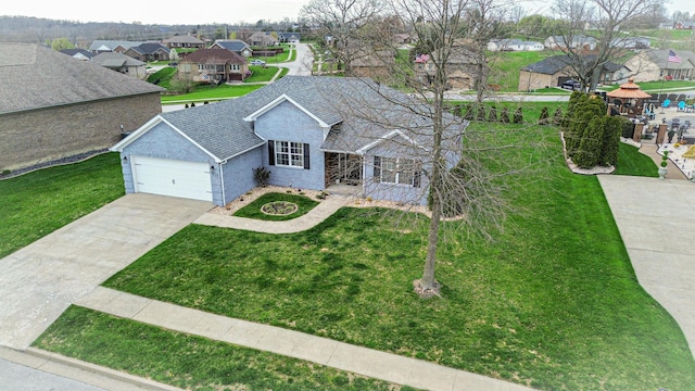 view of front facade featuring a residential view, a front yard, concrete driveway, and an attached garage