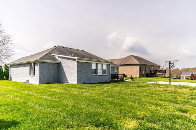 view of side of property with roof with shingles, a yard, and brick siding