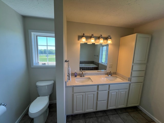 bathroom featuring tile patterned flooring, a sink, a textured ceiling, and toilet