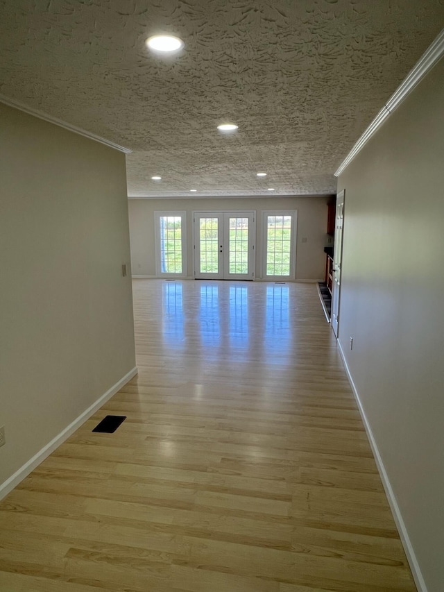 spare room with crown molding, baseboards, and a wealth of natural light