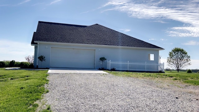 view of home's exterior with an attached garage, a shingled roof, and gravel driveway