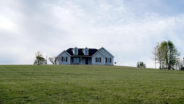 cape cod-style house featuring a rural view and a front lawn