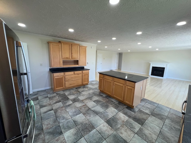 kitchen with recessed lighting, freestanding refrigerator, baseboards, and dark countertops