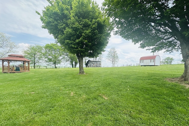 view of yard with a gazebo, an outbuilding, and a shed
