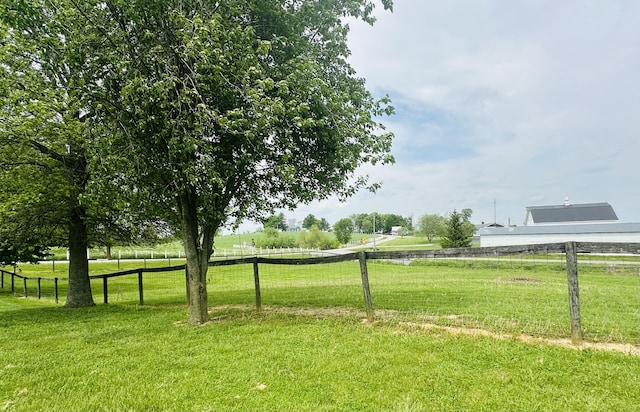 view of home's community with fence and a yard