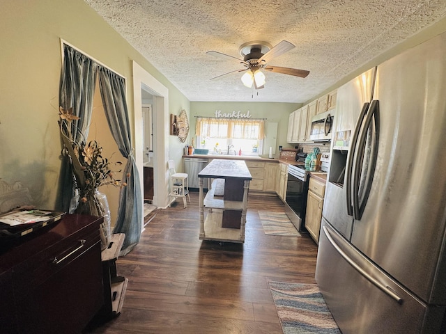 kitchen featuring a textured ceiling, ceiling fan, dark wood-style floors, and stainless steel appliances