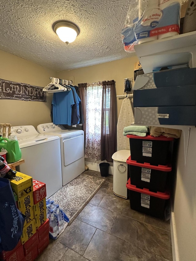 clothes washing area featuring laundry area, a textured ceiling, and washer and clothes dryer