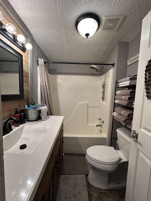 full bath with toilet, a textured ceiling, visible vents, and vanity