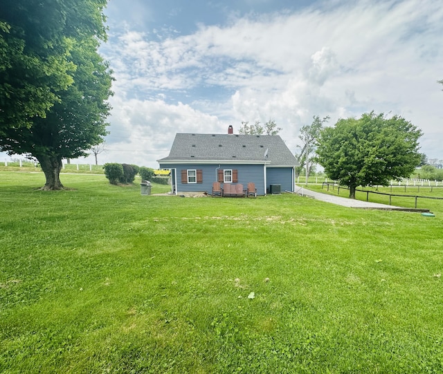 back of house featuring a garage, fence, a lawn, central air condition unit, and driveway