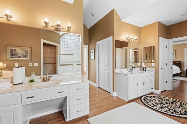 204 Helmsley Ln, Versailles, KY 40383 - full bathroom with two vanities, wood finished floors, vaulted ceiling, and ensuite bath
