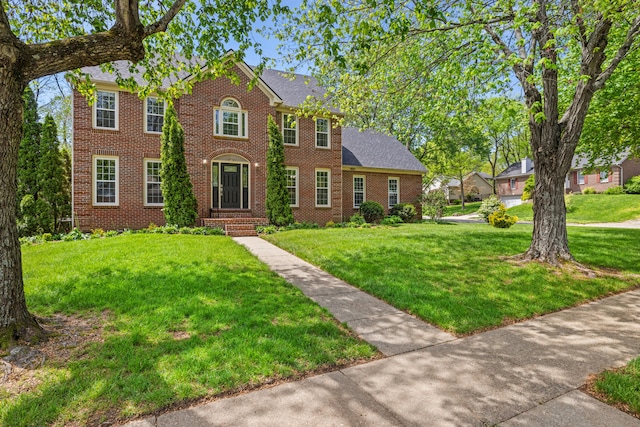 colonial home with a front lawn and brick siding