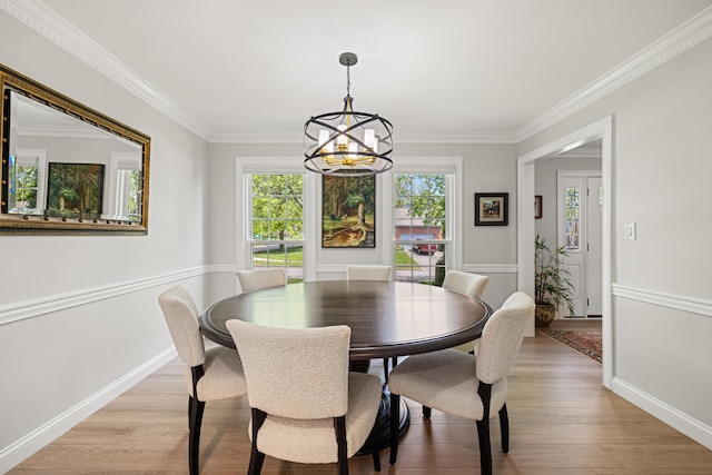 dining space featuring an inviting chandelier, light wood-style floors, crown molding, and baseboards
