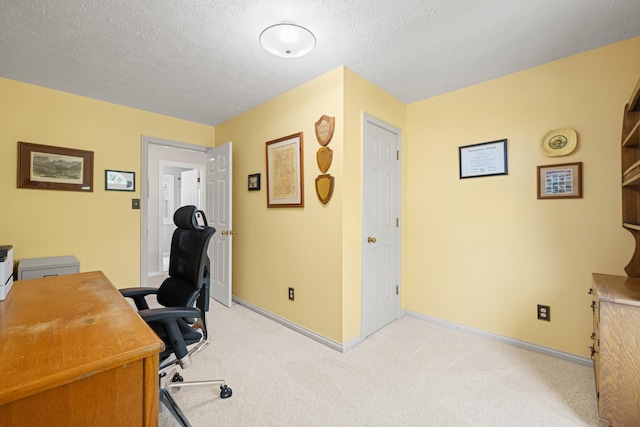 home office with light colored carpet, a textured ceiling, and baseboards