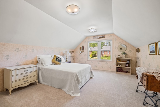 bedroom featuring carpet flooring, wallpapered walls, and lofted ceiling
