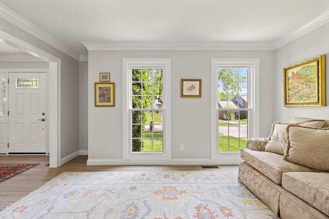 living room featuring crown molding, baseboards, a wealth of natural light, and wood finished floors