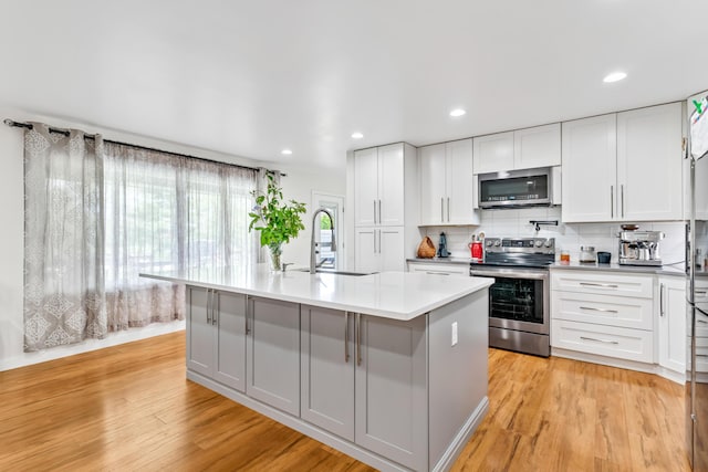 1144 Crenshaw Ln, Nicholasville, KY 40356 - kitchen with a sink, stainless steel appliances, light countertops, light wood-style floors, and decorative backsplash
