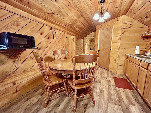 411 Alum Cave Rd, Annville, KY 40402 - dining space with lofted ceiling, wood walls, a chandelier, wooden ceiling, and light wood-type flooring