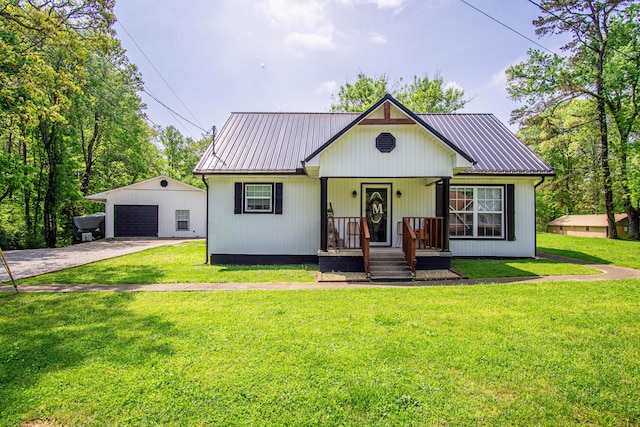 bungalow with concrete driveway, an outbuilding, metal roof, and a detached garage