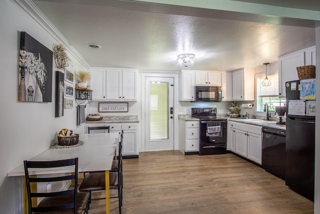 kitchen featuring a sink, light countertops, black appliances, dark wood-style floors, and white cabinetry