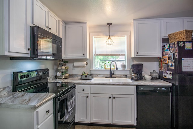 kitchen featuring a sink, light countertops, and black appliances