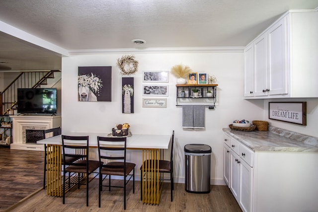 dining space with stairway, baseboards, visible vents, and dark wood-type flooring