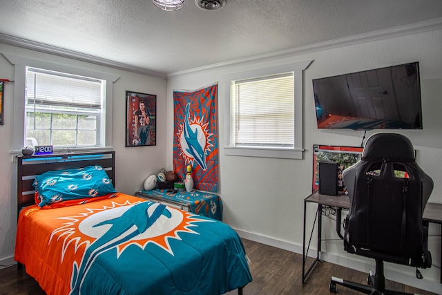 bedroom featuring baseboards, a textured ceiling, ornamental molding, and wood finished floors