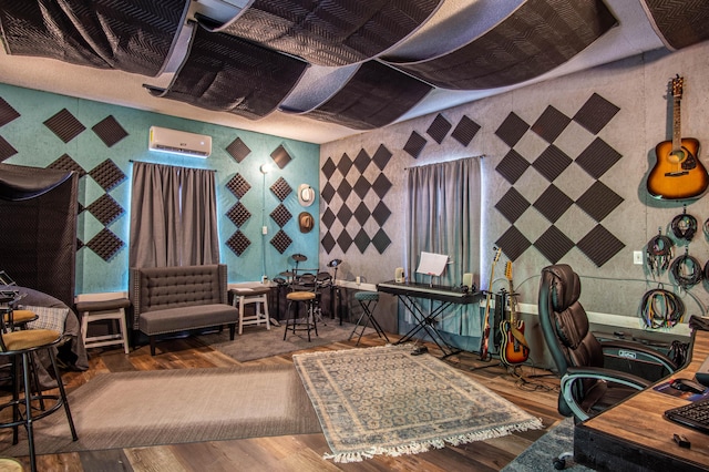 home office featuring wallpapered walls, a wall unit AC, and wood finished floors