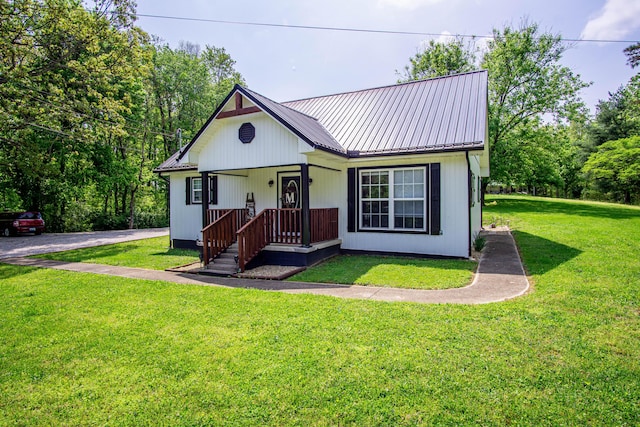view of front of house featuring metal roof and a front yard