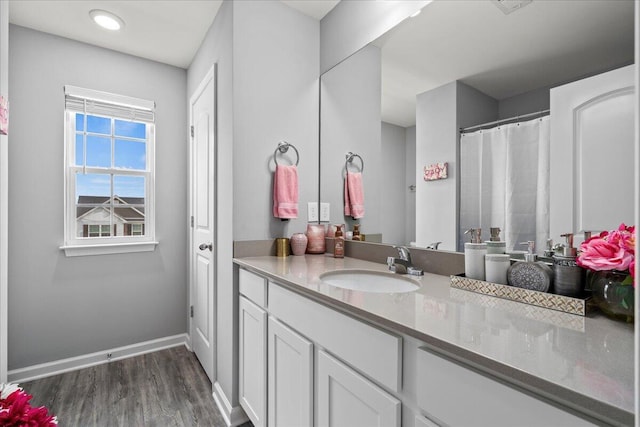 bathroom with vanity, baseboards, and wood finished floors