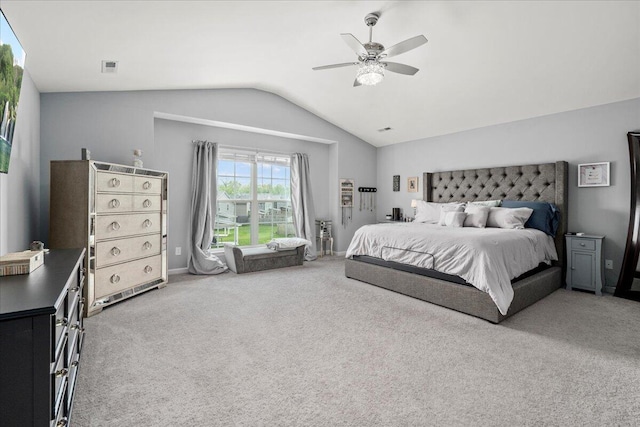 carpeted bedroom featuring ceiling fan, vaulted ceiling, and visible vents