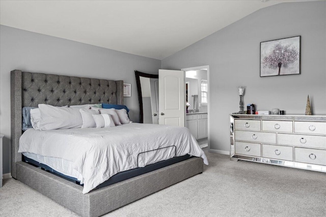 bedroom with carpet floors, baseboards, vaulted ceiling, and connected bathroom