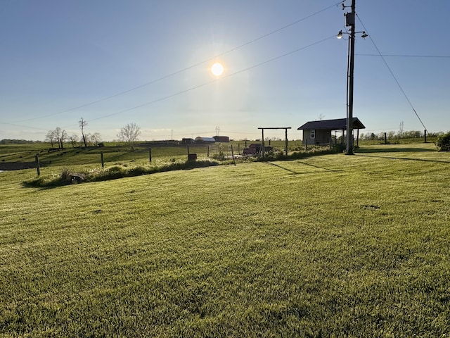 view of yard with a rural view and fence