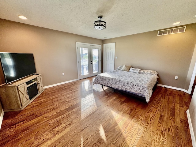 bedroom featuring french doors, a textured ceiling, visible vents, baseboards, and access to outside