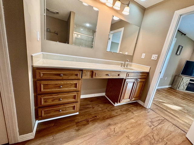 bathroom with baseboards, an enclosed shower, wood finished floors, and vanity