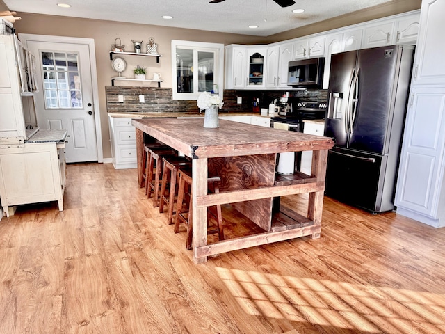 kitchen featuring a ceiling fan, white cabinetry, appliances with stainless steel finishes, and decorative backsplash