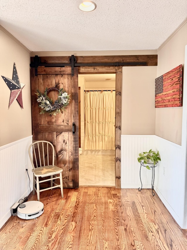 sitting room featuring a textured ceiling, wainscoting, and wood finished floors