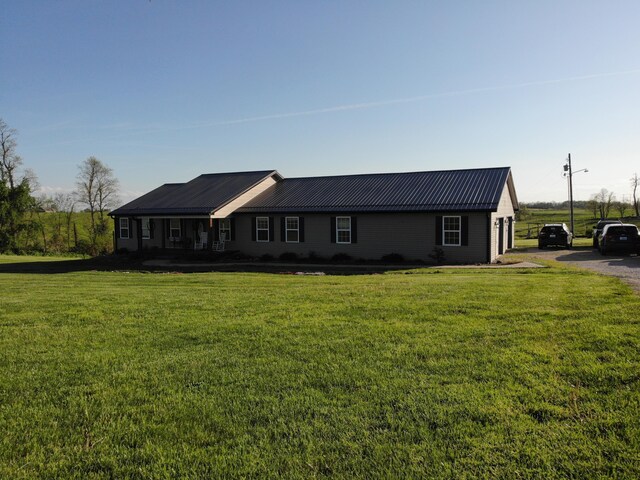 single story home with metal roof and a front yard